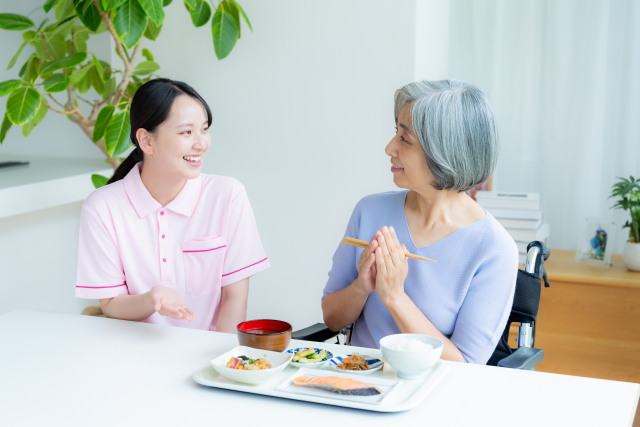食事のサポートを受ける高齢の患者様とスタッフ